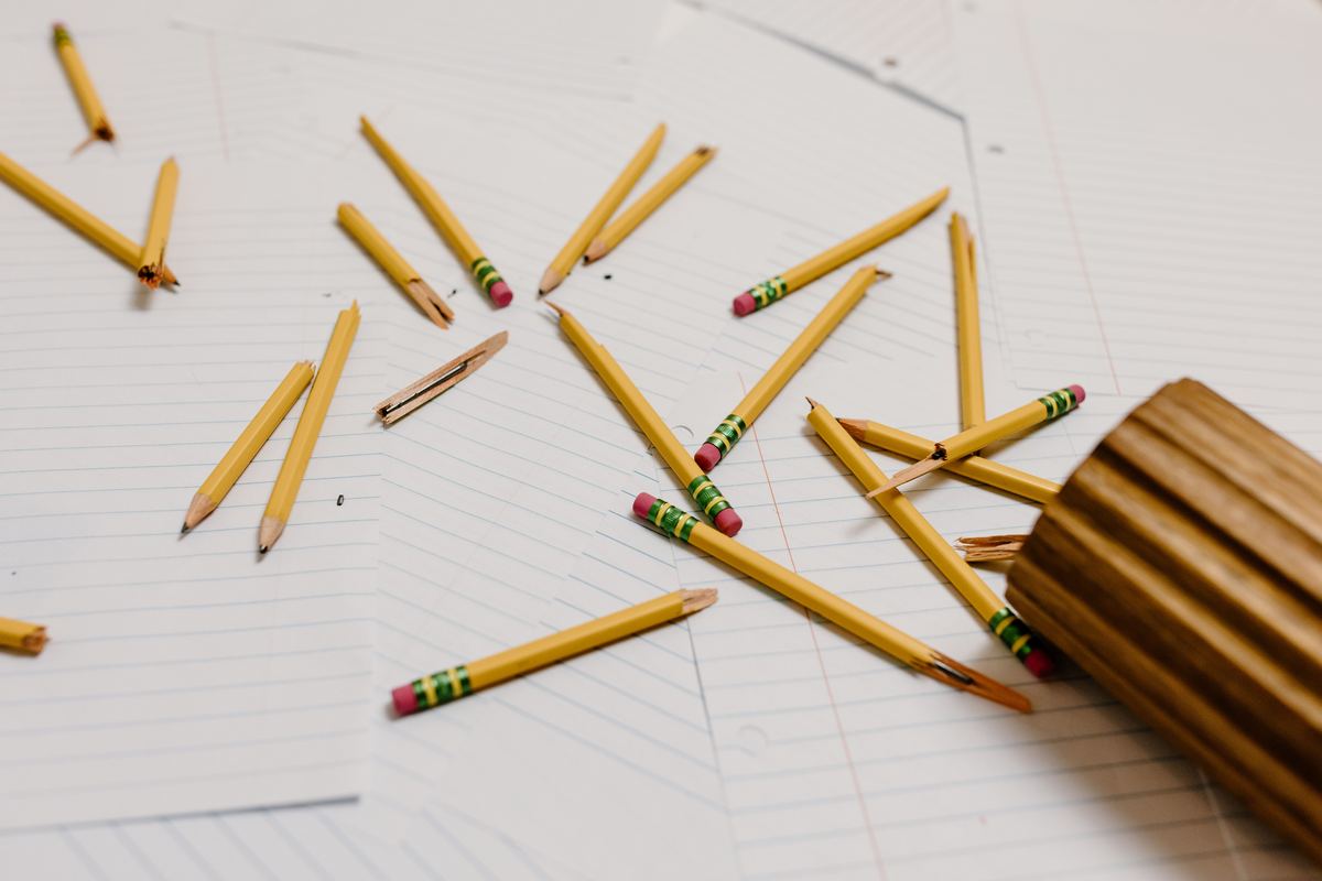 Broken pencils scattered across lined paper