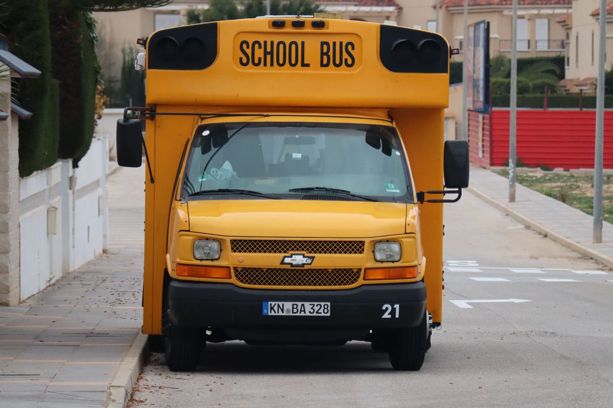 A yellow school bus parked on a quiet residential street