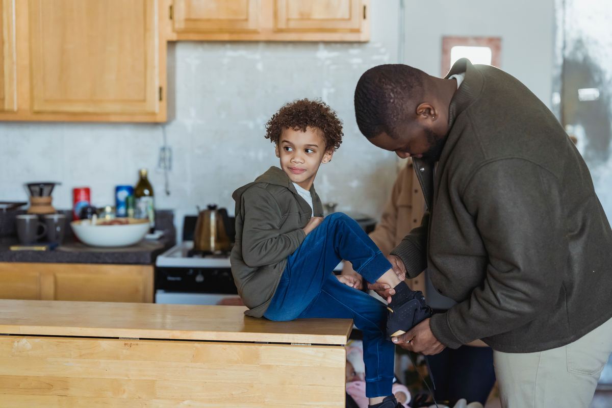 A parent helping a child put on their shoes