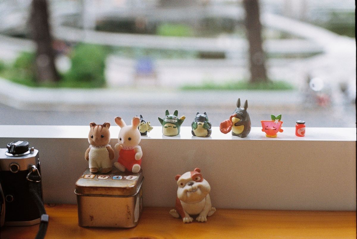 Small toy figures arranged along a window shelf