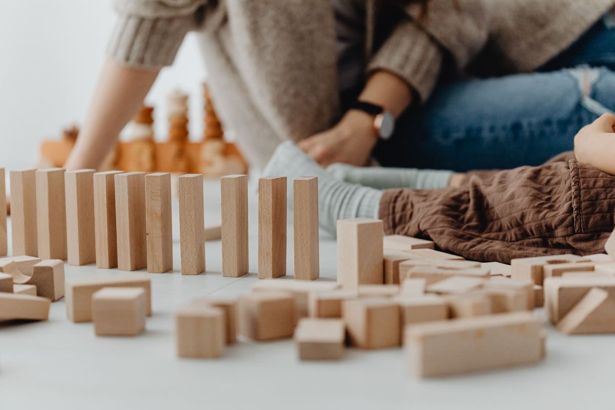 A child building carefully with wooden blocks