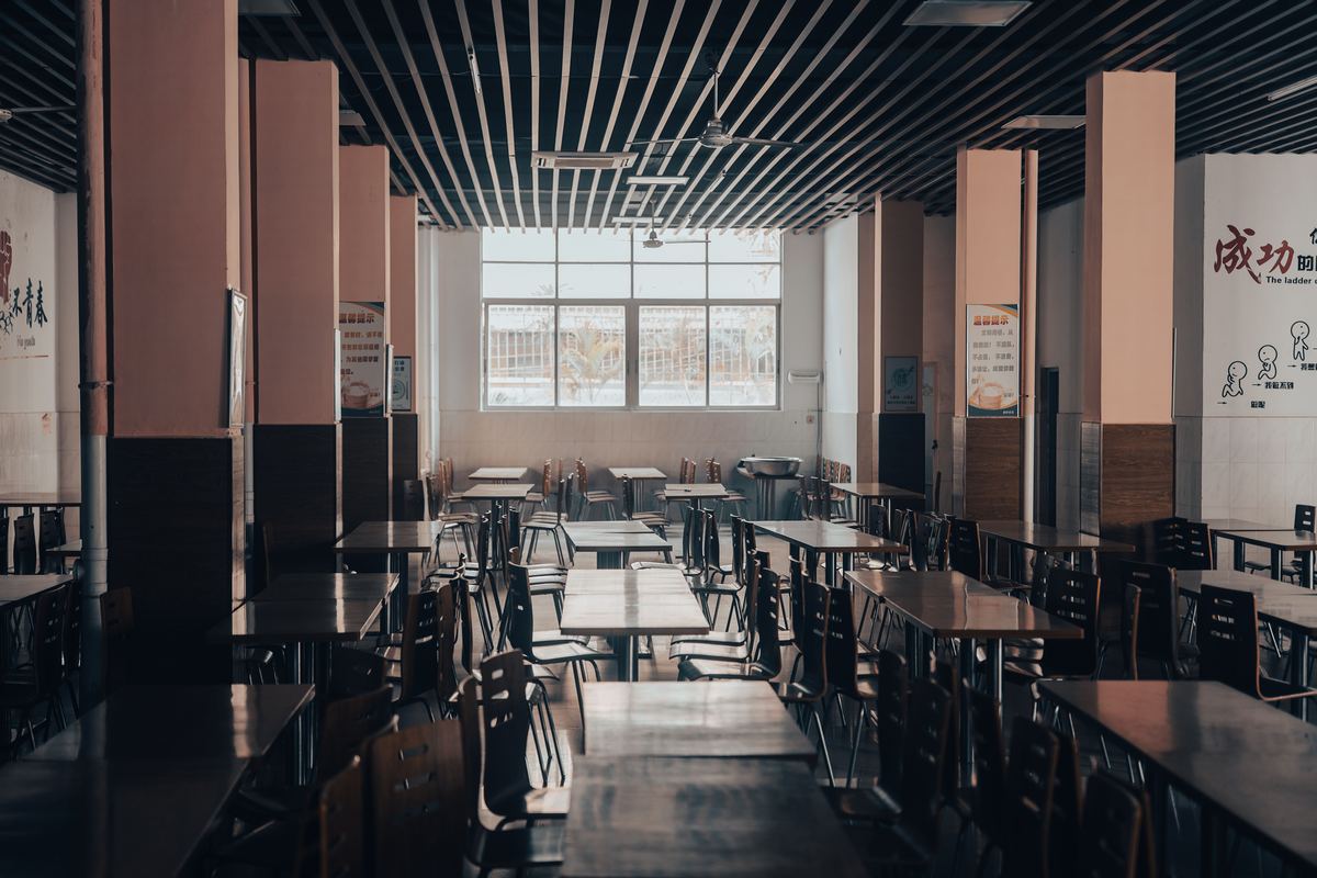 Empty wooden tables and chairs in a school cafeteria