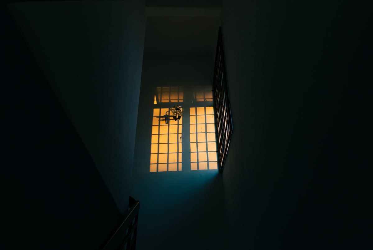 A dimly lit hallway with warm light coming through a window