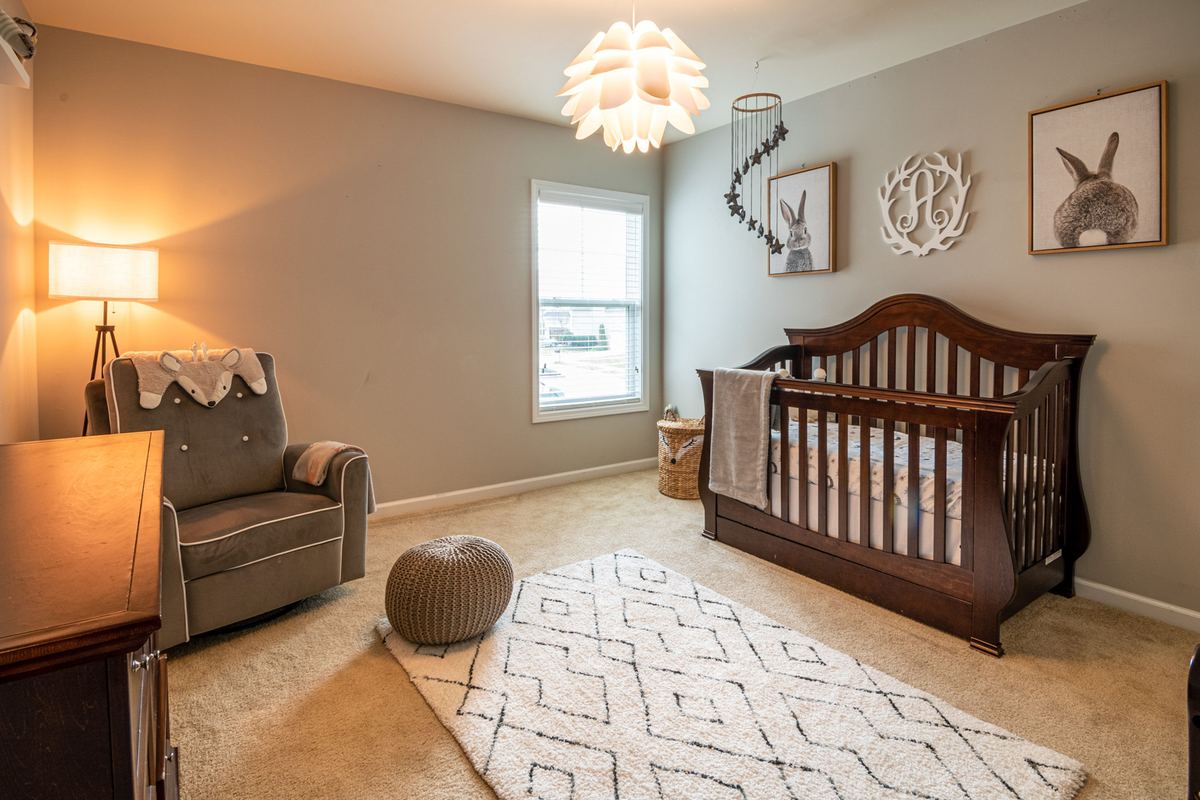 A quiet nursery with a crib and armchair in daylight