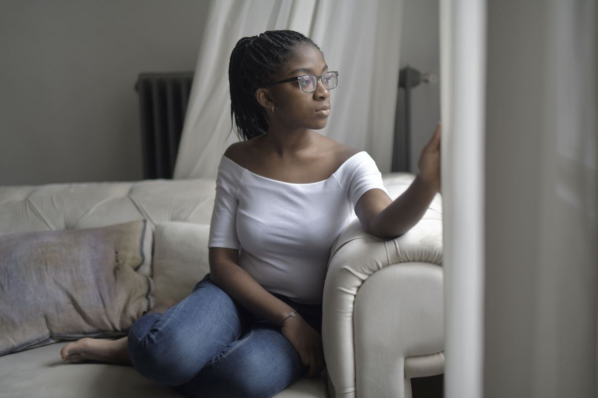 A person sitting near a window, deep in thought