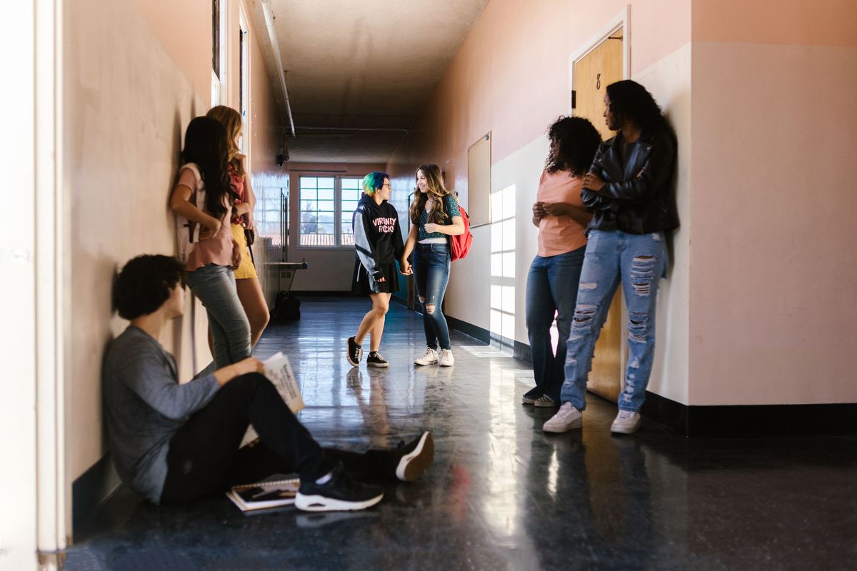 Students sitting and talking in a school hallway between classes