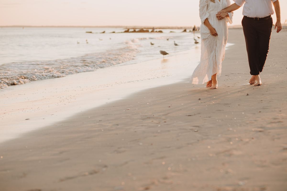A couple walking hand in hand along the shoreline