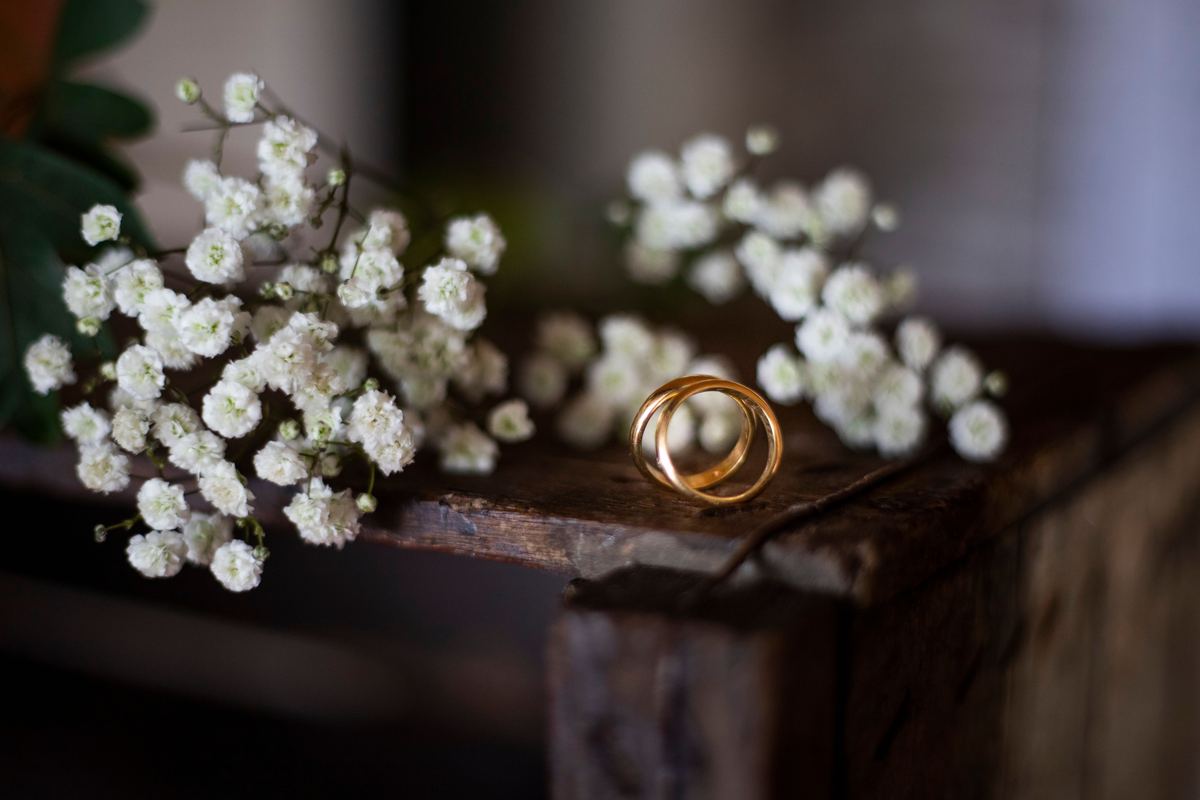 Two gold wedding rings on a wooden surface