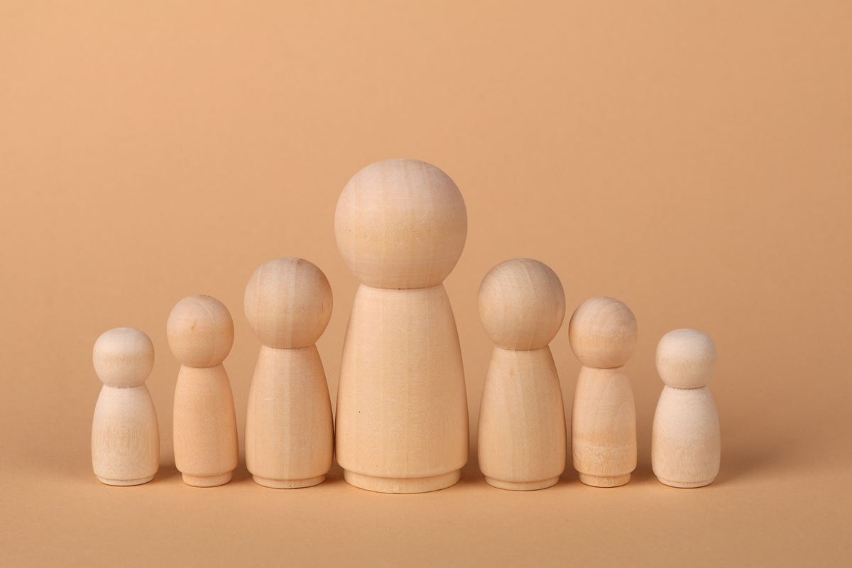 A row of wooden peg dolls arranged from tallest to smallest
